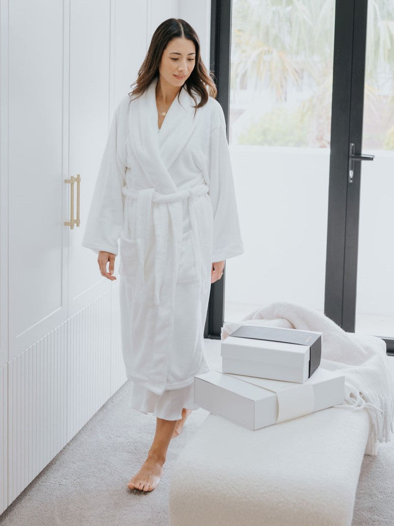 Women walking in her beautiful walk in closest with robe and looking at her new Parcelle Gifts that have been delivered