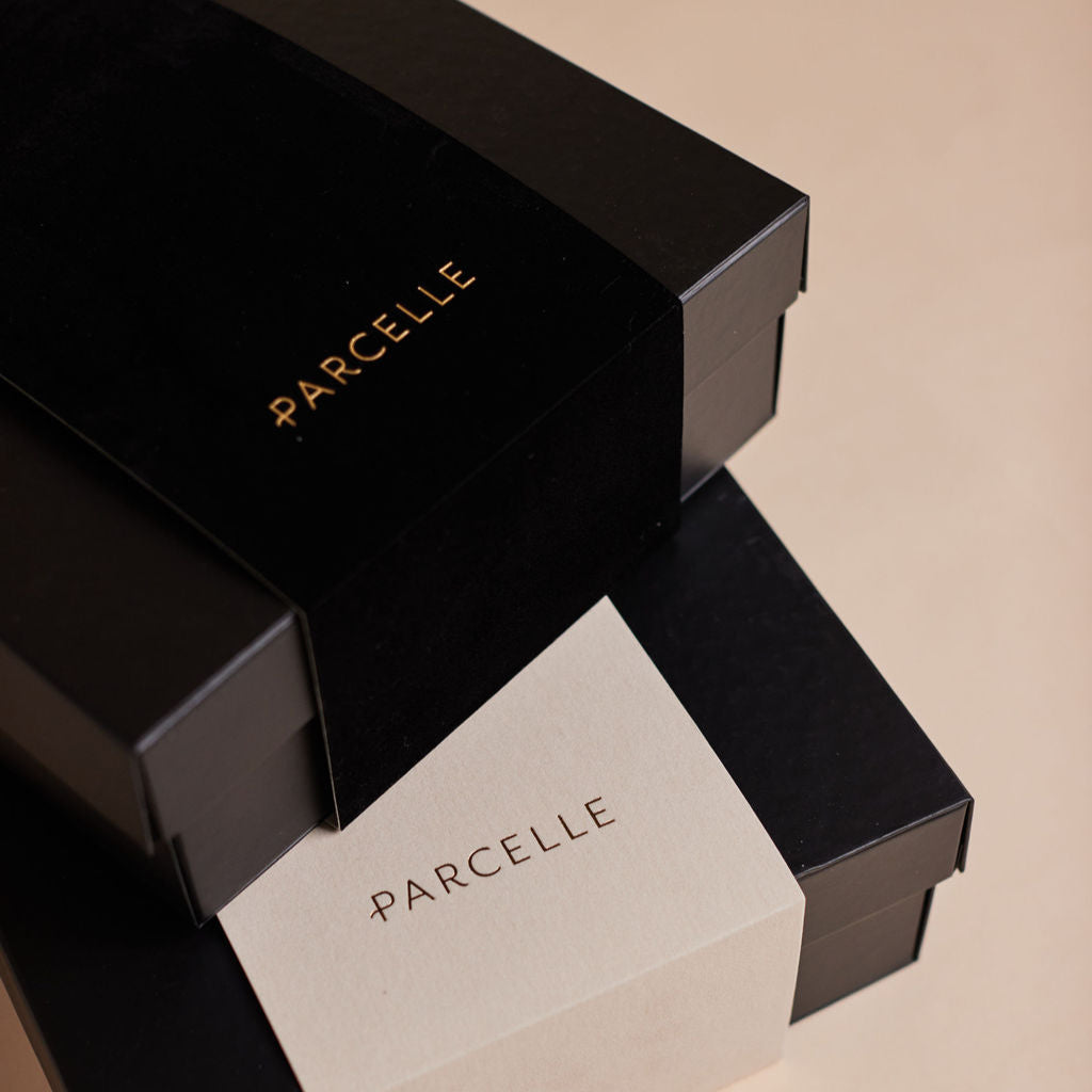 Parcelle | Stack of Parcelle signature gift boxes with velvet touch ivory and black sleeves — luxury corporate hampers and settlement gifts exquisitely presented in Sydney