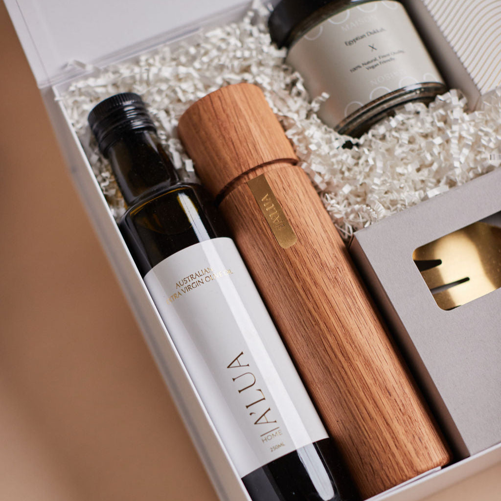 Parcelle | The Kitchenette real estate settlement hamper with olive oil, artisan crackers, wooden grinder, and gold trinket dish in Parcelle signature gift box