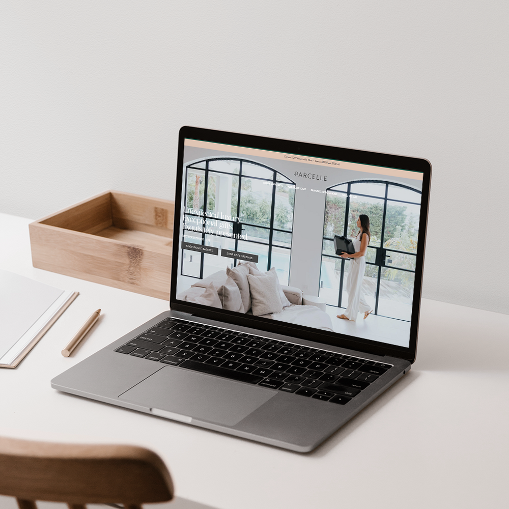 Parcelle | Laptop displaying Parcelle luxury hampers website on a styled tabletop scene — modern corporate gifting, settlement gifts, and Christmas hampers Sydney.