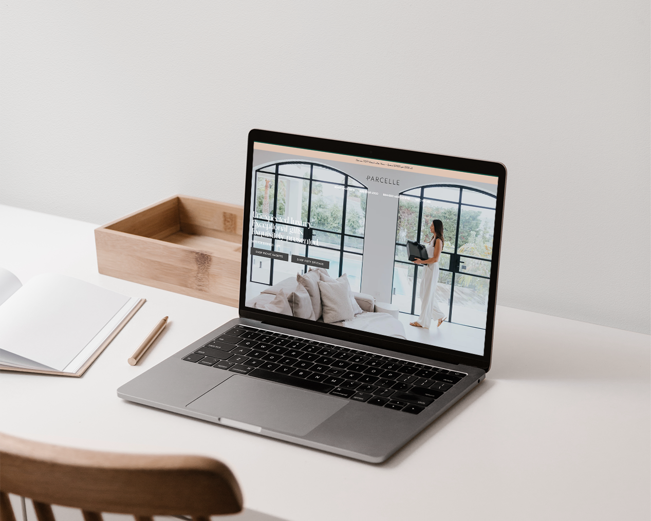 Parcelle | Laptop displaying Parcelle luxury hampers website on a styled tabletop scene — modern corporate gifting, settlement gifts, and Christmas hampers Sydney.