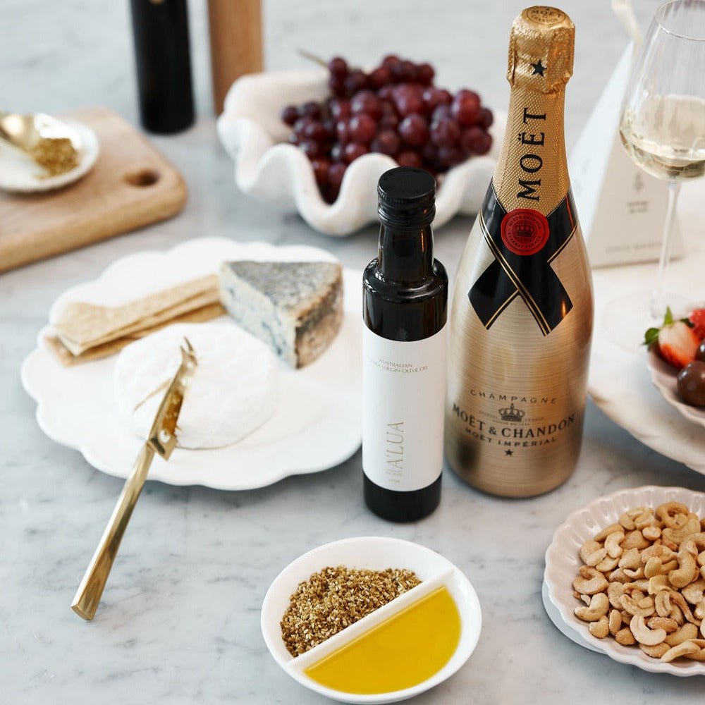 
                      
                        Parcelle | The Joyous Christmas gift hamper displayed on a holiday table, featuring a selection of Coco Maison artisan crackers, BBQ spice cashews, and chocolate-coated macadamias.
                      
                    