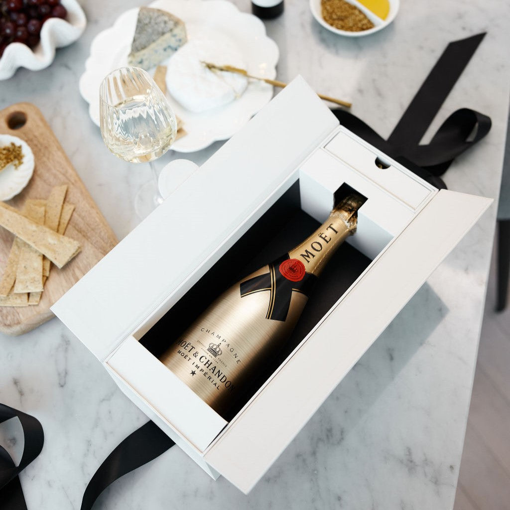 Parcelle | Beautiful luxurious champagne double door gift box with hidden drawer for delicious chocolate presented open on a marble kitchen dining table with wine glasses and goumet goodies