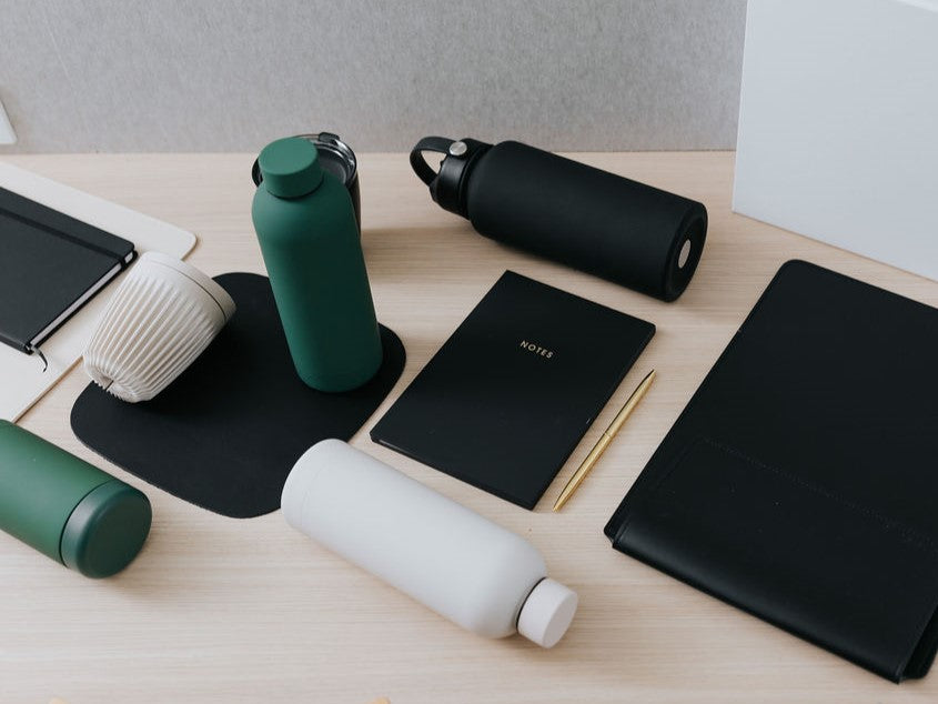 Parcelle | Premium Custom Branded Merchandise Products including branded drink bottles, branded mouse pad, personalised vegan leather ipad holder, personalised notebook and branded pen on a desk