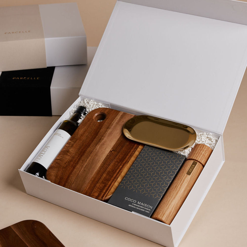 Parcelle | The Condo real estate settlement hamper with olive oil, artisan crackers, wooden salt & pepper grinder, and gold trinket dish in Parcelle gift box