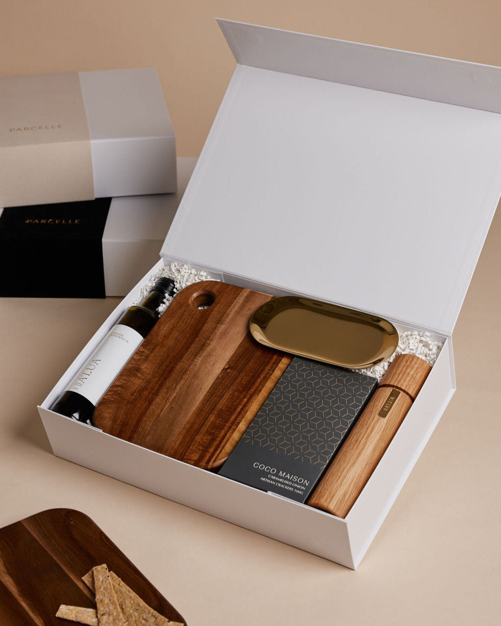 Parcelle | The Condo real estate settlement hamper with olive oil, artisan crackers, wooden salt & pepper grinder, and gold trinket dish in Parcelle gift box