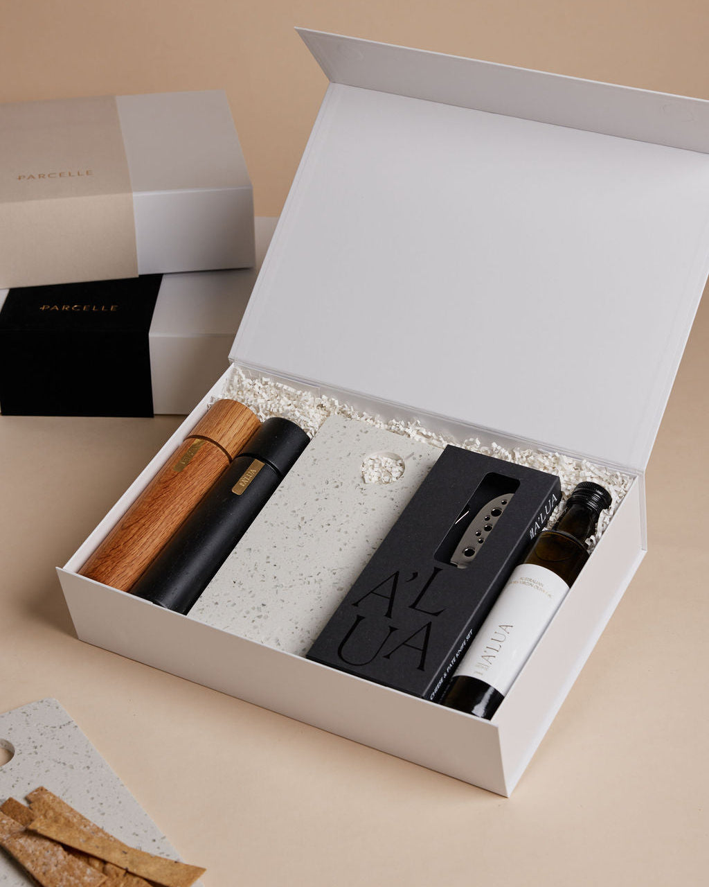 Parcelle | The Terrace luxury property settlement hamper with olive oil, terrazzo stone serving board, wooden grinders, and cheese knife set in Parcelle gift box