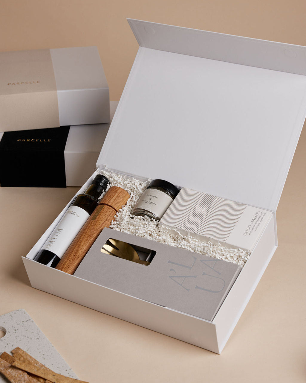 Parcelle | The Kitchenette real estate settlement hamper with olive oil, artisan crackers, wooden grinder, and gold trinket dish in Parcelle signature gift box