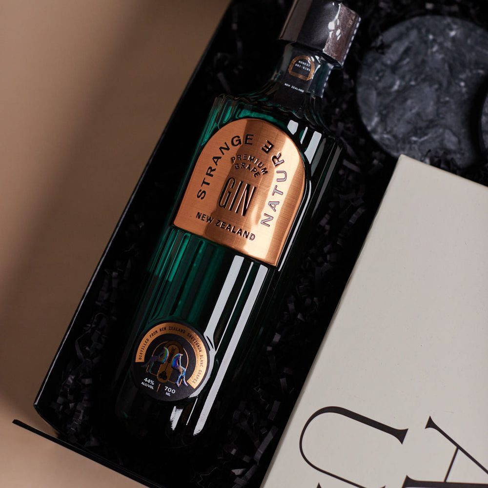 Parcelle | Luxury Christmas gin hamper featuring Strange Nature Gin, Pistachio Knafeh Chocolate, festive Panettone, tumblers and coasters, presented in Parcelle Signature Gift Box
