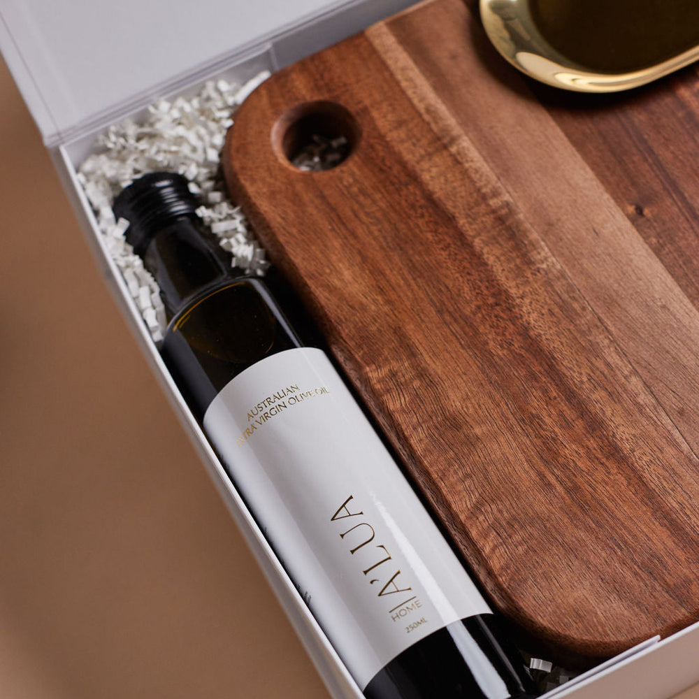 Parcelle | The Condo real estate settlement hamper with olive oil, artisan crackers, wooden salt & pepper grinder, and gold trinket dish in Parcelle gift box