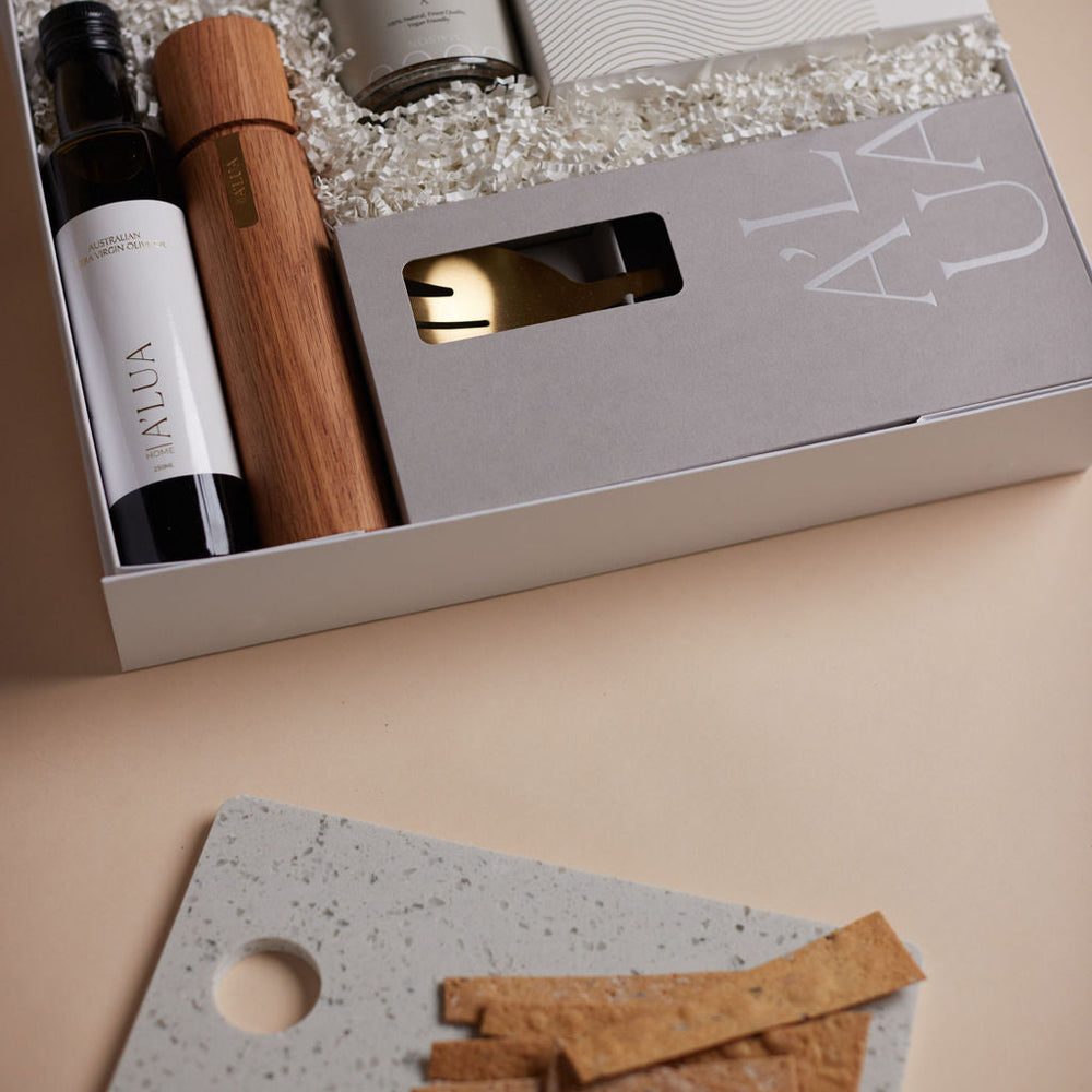 Parcelle | The Kitchenette real estate settlement hamper with olive oil, artisan crackers, wooden grinder, and gold trinket dish in Parcelle signature gift box