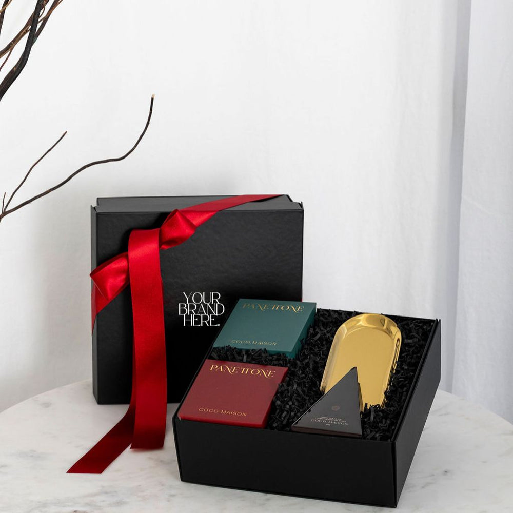Parcelle | Dolce Christmas luxury hamper with Traditional and Choc Chip Panettone, Milk Chocolate Macadamias, and a Gold Tray, presented in Parcelle gift box with festive sleeve, free branding available.